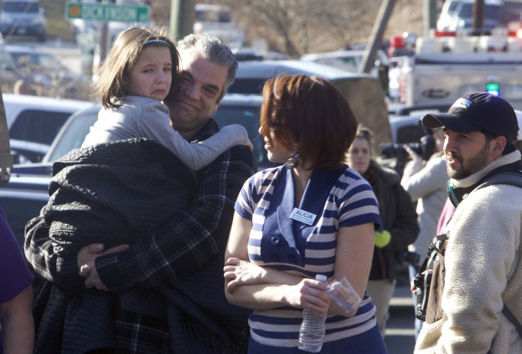 Parents pick-up children outside Sandy Hook Elementary School after a shooting in Newtown